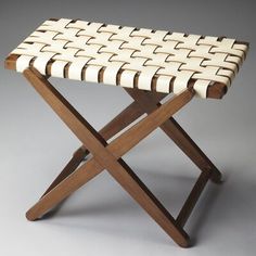 a wooden stool with a white woven seat cover on it's back and legs