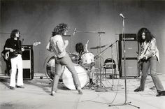 an old black and white photo of some people playing guitar in front of microphones