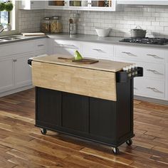 a kitchen island with cutting board on it in the middle of a hardwood flooring area