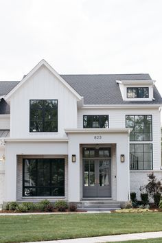 a white two story house with black windows