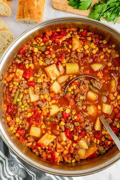 a large pot filled with soup next to bread