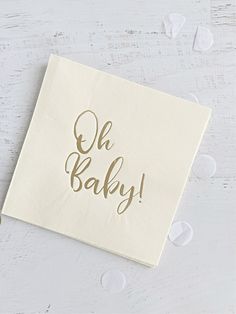 a napkin with the words oh baby printed on it and hearts around it, sitting on a white surface