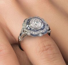 a woman's hand with a green and white ring on it