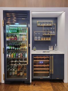 an open refrigerator in a kitchen next to a counter with bottles and glasses on it