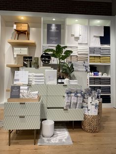 a store display with lots of folded towels and other items on the shelves in front of it