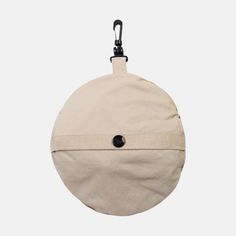 a round bag hanging from a hook on a white background with a black button in the middle