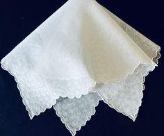 This is an elegant vintage sheer white lawn hankie printed with an all over opaque design of lilies of the valley and featuring a stylized scalloped hem. It measures 16 inches and is in excellent gift giving condition.  With all the tears of joy at weddings, vintage hankies make great gifts for brides, bridesmaids, mothers of the bride, mothers of the groom, godmothers, grandmothers, sisters, or just that special friend.    Offered with these hankies is an optional elegant papercut gift envelope tied with a satin ribbon, such as highlighted in the last photo.  This is the perfect holder in which to present this beautiful keepsake to one of these special people whether it is for a wedding, a shower, a birthday, a holiday, or just for fun. Find more of my vintage hankies here:  https://www.e Classic White Wedding Handkerchiefs, Lily Of The Valley Wedding, Gifts For Brides, Lilies Of The Valley, Wedding Hankies, Vintage Hankies, Gift Envelope, White On White, Valley Wedding