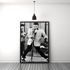 a black and white photo of a man singing into a microphone in an empty room