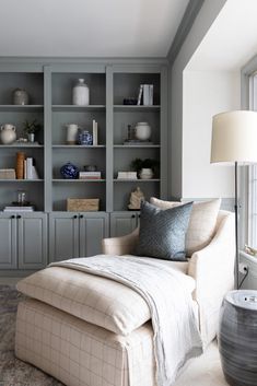 an instagram photo of a living room with gray bookcases