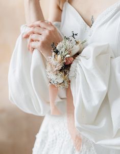 a close up of a person wearing a white dress and holding a flower in her hand