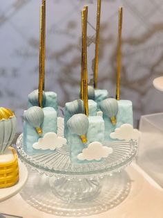 there is a cake with blue frosting and gold decorations on the top, as well as hot air balloons