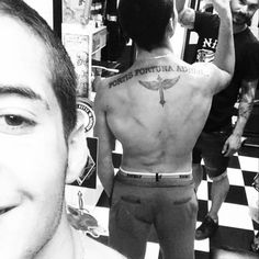 a man with a cross tattoo on his back