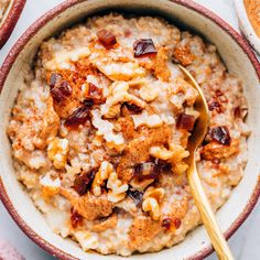 a bowl filled with oatmeal topped with nuts and raisins