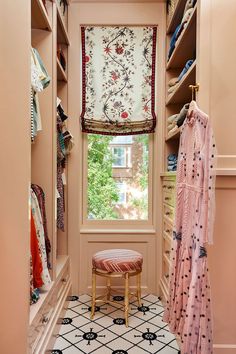 a walk - in closet with a bench and window