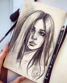 a pencil drawing of a woman's face on a notepad with two markers