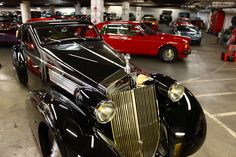 an old black car parked in a parking garage