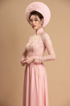 a woman in a pink dress and hat poses for the camera with her hands on her hips