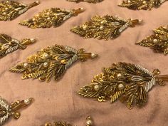 gold brooches and pearls on a pink cloth