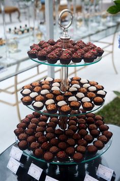 three tiered trays filled with cupcakes sitting on top of a table