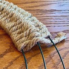 a close up of a knitted object on a wooden table with wires attached to it