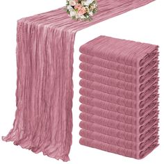 a stack of pink towels next to a bouquet of flowers on top of each towel