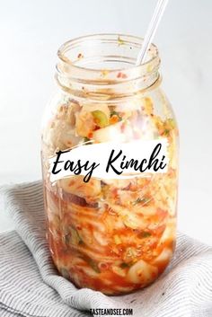 a glass jar filled with food sitting on top of a cloth next to a spoon