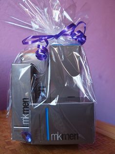 an open box with a purple ribbon on the top and another package wrapped around it