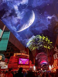 fireworks are lit up in the night sky above neon signs and buildings at las vegas