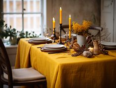 the table is set with yellow linens and place settings