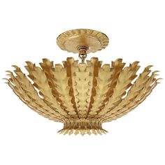 a golden chandelier hanging from the ceiling with an intricate design on it's center