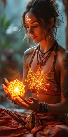 a woman with tattoos holding a glowing item in her hands