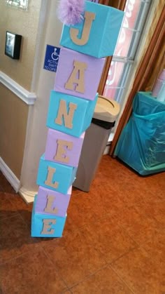 a purple and blue block sign that says janee on it in front of a door