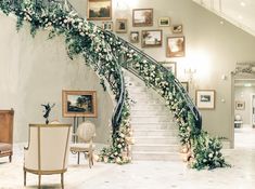 an elegant staircase decorated with flowers and greenery