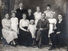 an old black and white photo of a family posing for a group shot in formal dress