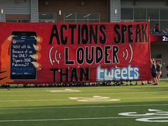 a large sign on the side of a football field that says actions speak louder than tweets