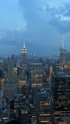 the city skyline is lit up at night, with skyscrapers in the foreground