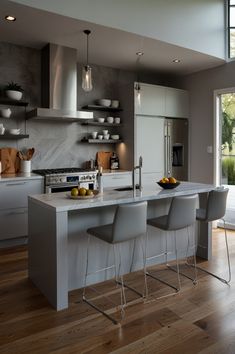 a modern kitchen with stainless steel appliances and white countertops is pictured in this image