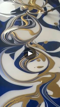 an abstract painting with gold and blue swirls on the bottom, as well as black and white lines