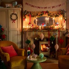 a living room filled with furniture and a fire place covered in christmas garlands next to a fireplace