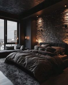 a large bed sitting in the middle of a bedroom next to a tall brick wall