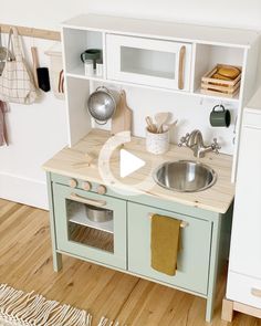 a wooden play kitchen with sink and cupboards