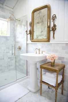 a bathroom with a sink, mirror and stand up shower