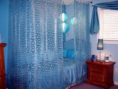 a bedroom with blue walls and curtains in it