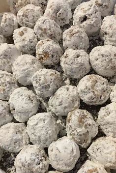 a bowl filled with snowball cookies and powdered sugar