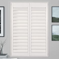 white shutters in a living room with pictures on the wall and paintings above them