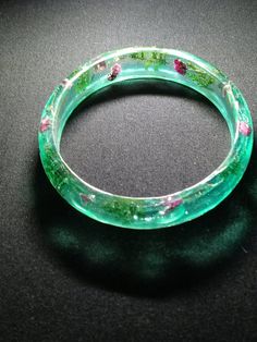 Resin bangle with real dried flowers and evergreen sprigs encapsulated Resin Bangle Jewelry Gift, Resin Bangle Jewelry For Gifts, Clear Bangle Bracelet As A Gift, Clear Bangle Bracelet For Gifts, Handmade Resin Bangle, Adjustable Resin Bangle Jewelry, Green Cuff Bracelet Gift, Adjustable Bracelets With Pressed Flowers, Adjustable Round Bracelets With Pressed Flowers