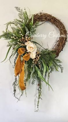 a close up of a wreath with flowers and greenery on the front of it