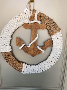 a wreath made out of rope with an anchor hanging from the front and side of it