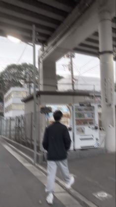 the man is walking down the street with his skateboard