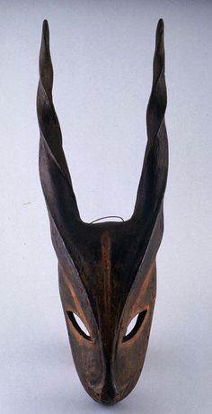 a brown mask with long horns on it's head is shown in front of a white background